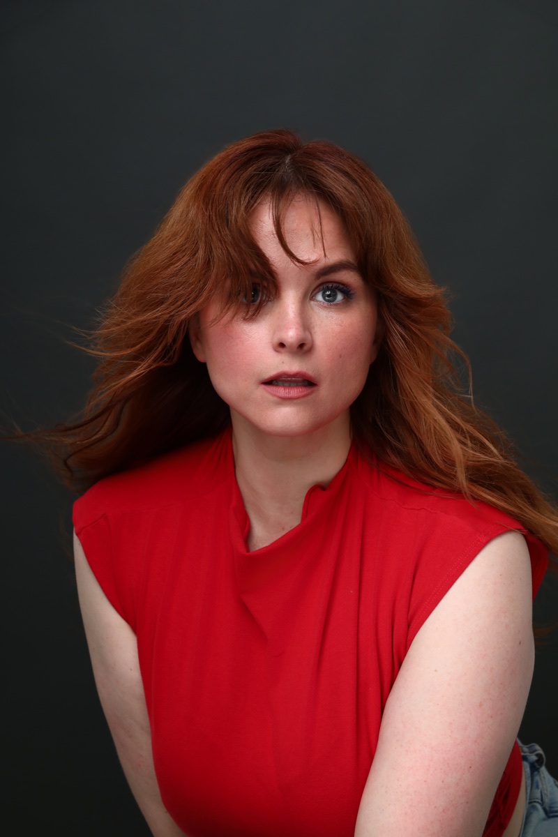 Blaire Erskine looking startled in a red top.