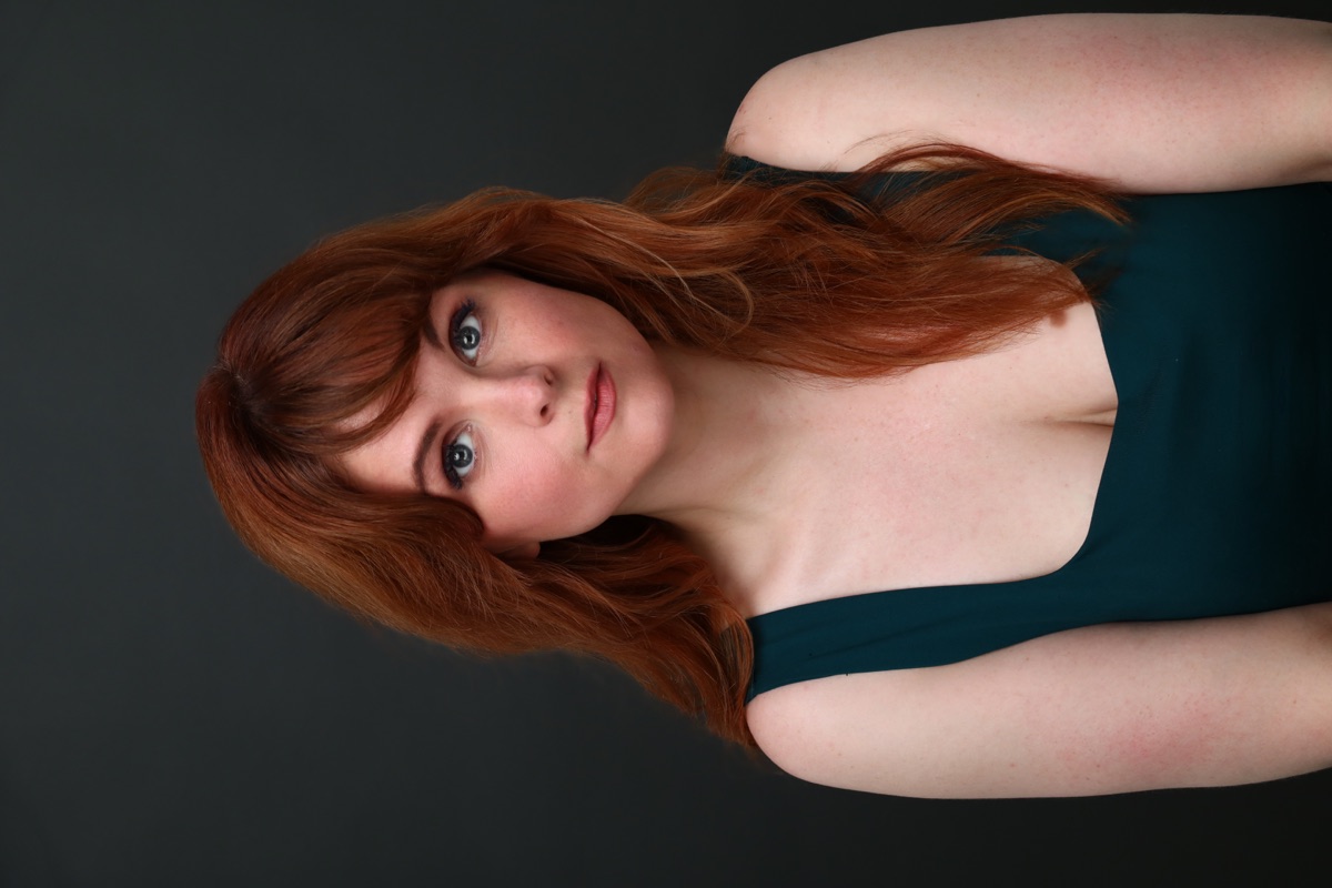 Blaire Erskine in a deep green top, theatrical portrait.