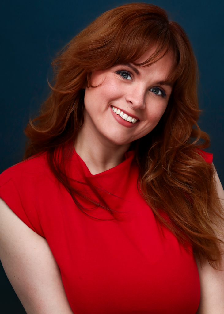 Blaire Erskine smiling in a red top.